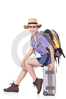 Woman traveler sitting on suitcase with backpack