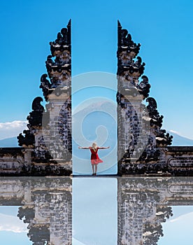 Woman traveler standing at the ancient gates of Pura Luhur Lempuyang temple aka Gates of Heaven in Bali