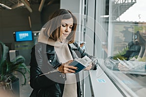 Woman traveler standing near panoramic big window at airport. Lady waiting for flight. Travel, journey, airplane concept