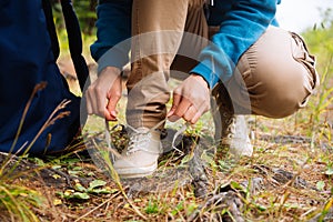 Woman traveler strikes up a shoelaces