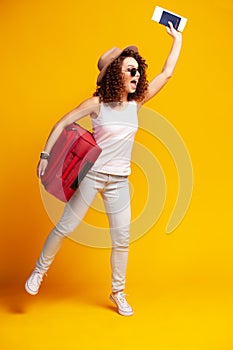 Woman traveler with suitcase on color background.