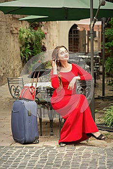 Woman traveler with suitcase at restaurant outdoor