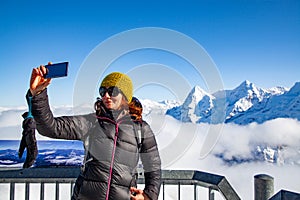 woman traveler in Swiss alps Jungfrau region taking pictures