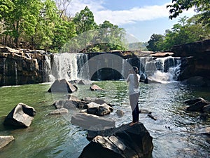 Woman traveler taking photo with camera at Tat Ton waterfall