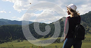 Woman traveler tourist admiring amazing view in mountains valley with river.