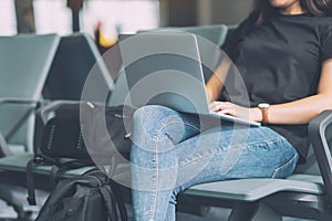 A woman traveler using laptop computer in the airport