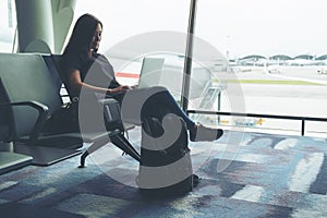 A woman traveler using laptop computer in the airport