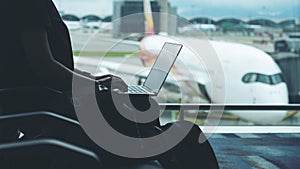 A woman traveler using laptop computer in the airport