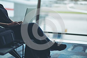 A woman traveler using laptop computer in the airport