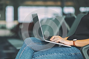 Woman traveler using laptop computer while sitting in the airport