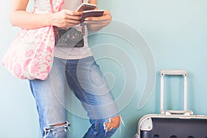 Woman traveler using smart phone and passport book with traveler