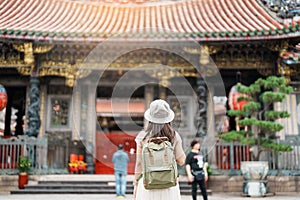 woman traveler visiting in Taiwan, Tourist with hat sightseeing in Longshan Temple, Chinese folk religious temple in Wanhua photo