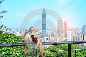 woman traveler visiting in Taiwan, Tourist looking Taipei City during sightseeing and hiking at Elephant Mountain or Xiangshan,