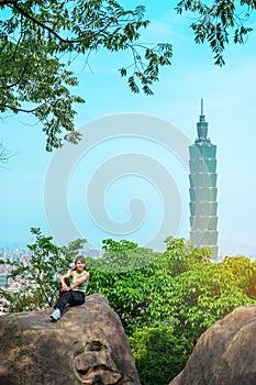 woman traveler visiting in Taiwan, Tourist looking Taipei City during sightseeing and hiking at Elephant Mountain or Xiangshan,