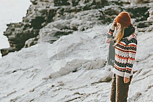 Woman traveler walking alone at rocky seaside Travel Lifestyle fashion concept winter vacations outdoor
