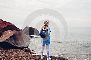 Woman traveler walking enjoying Red beach in Santorini island, Greece. Tourism, summer traveling