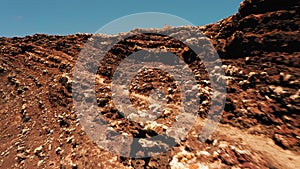 Woman traveler walking through the lava field crater of Calderon Hondo volcano. Fuerteventura, Canary Island, Spain. Go