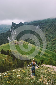 Woman traveling alone enjoying foggy mountains view  hiking adventure vacations