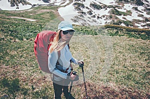 Woman traveling with backpack hiking in mountains