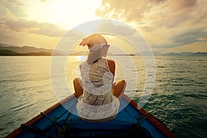 Woman traveling by boat at sunset among the islands.