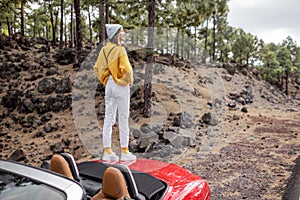 Woman traveling by car in the mountain forest