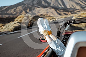 Woman traveling by convertible car on the desert valley