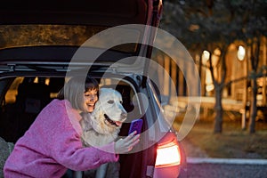 Woman traveling with a dog by car on nature