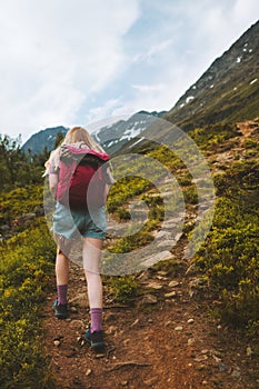 Woman traveling in mountains hiking with backpack