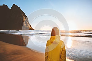 Woman traveling in Norway Lofoten islands enjoying Kvalvika beach sunset ocean