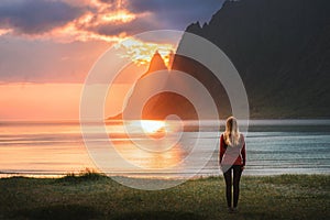 Woman traveling in Norway walking alone on sunset Ersfjord beach harmony with nature healthy lifestyle