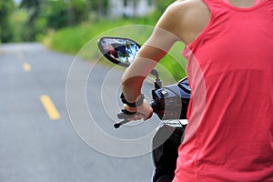 Woman traveling by a scooter on country road