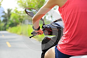 woman traveling by a scooter on country road