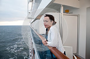 Woman traveling on ship and hold on handrails photo