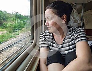 A woman traveling on a train looks out of the window