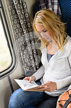 Woman traveling by train and reading book