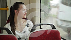 Woman traveling by tram in city. Passenger public transport watching the street while driving by tram-car