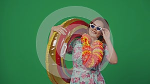 Woman traveller in glasses and flower wreath holds inflatable tube ring, having fun on vacation, posing at the camera