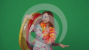 Woman traveller in glasses and flower wreath holds inflatable tube ring over shoulder, smiling posing at the camera