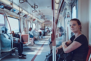 Woman travels overground metro in the afternoon