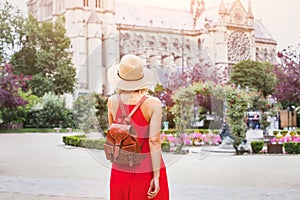 Woman travels to Paris, tourist with backpack near Notre Dame, France