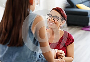 Woman Treating Scratch On Her Daughter Leg At Home