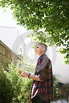 Woman, tree and thinking in garden by home for summer morning, fresh air or planning for day. Relax, nature and