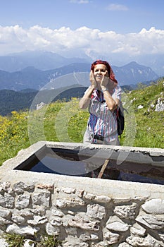 Woman trekker refreshing high in the mountains