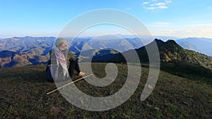 Woman trekker sitting on top doi pui highest mountain peak of maehong sorn province northern of thailand