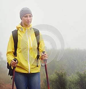 Woman, trekking and fitness in nature with pole for backpacking, travel and outdoor adventure. Journey, path and female