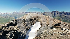 Woman trekking in high altitude rocky mountain landscape. Summer adventures on the Italian French Alps