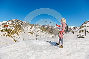 Woman with trekking poles sunset