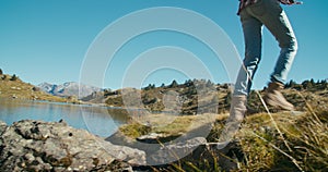 Woman in trekking shoes crossing mountain river on vacation travel adventure