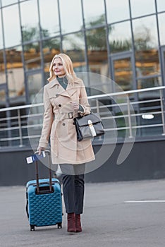 Woman in trench coat with luggage
