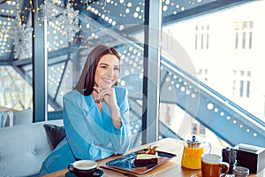 Woman in trendy autumn outfit chilling in cozy cafe, daydreaming